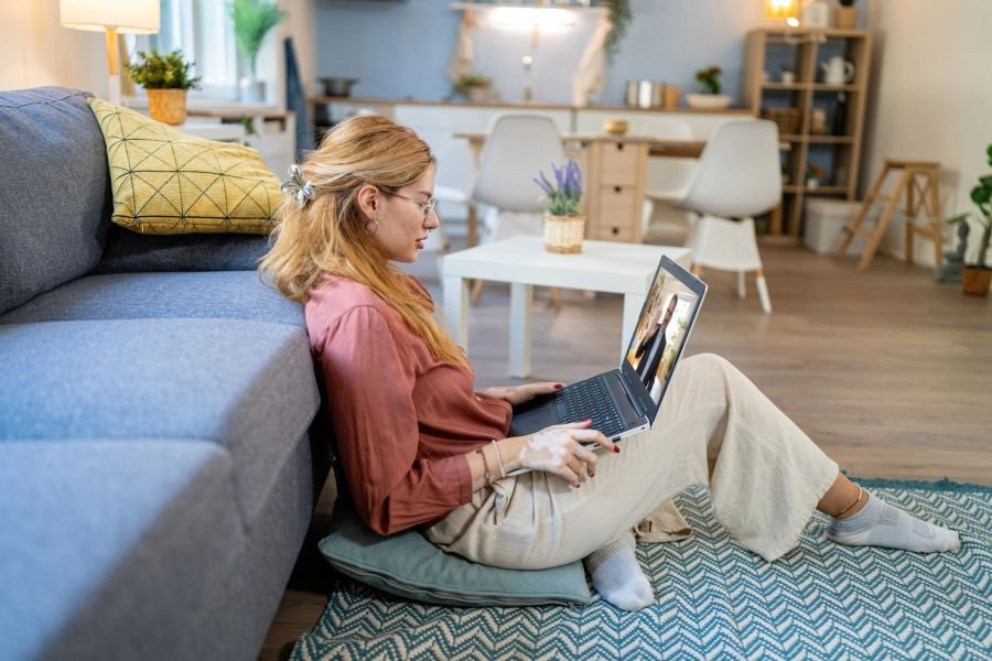Woman on a couch using a laptop